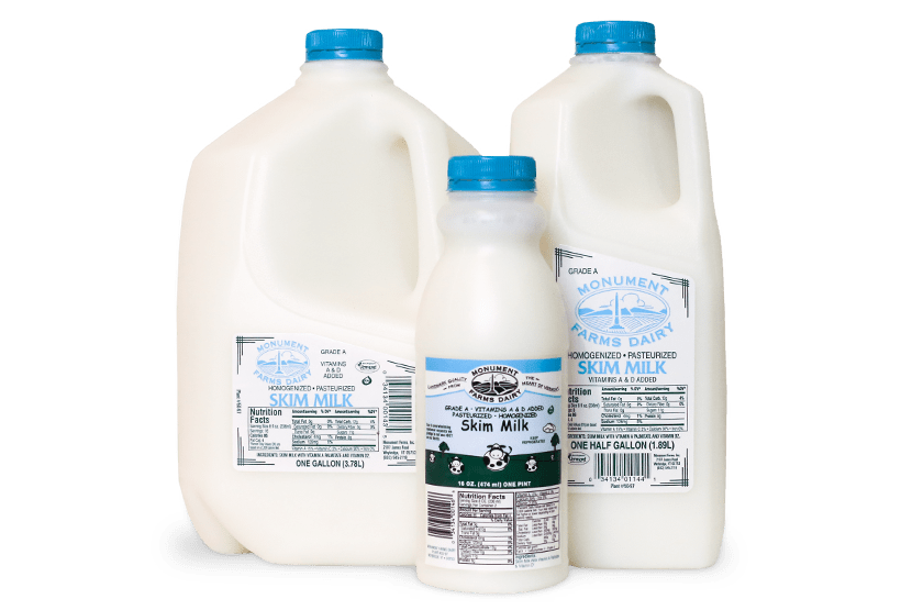 A pint, half gallon, and gallon jug of Monument Farms local skim milk.