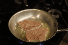 Chicken is browned and flipped in a pan. Step two of the Champagne Chicken recipe shared by the chefs at Fire and Ice Restaurant as one of their local Vermont recipes made with Monument fresh local heavy cream.