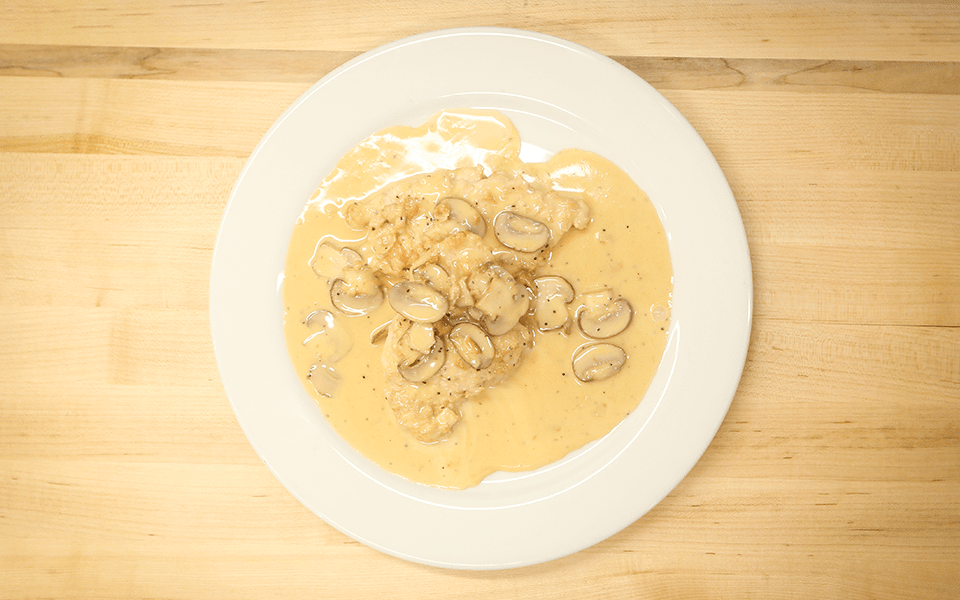A delicious plate of chicken and mushrooms in a creamy champagne sauce, created by the chefs at Fire and Ice Restaurant as one of their local Vermont recipes made with Monument fresh local heavy cream.