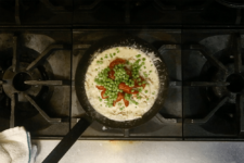 Roasted tomatoes and peas added. Step seven in the Cavatappi Carbonara recipe shared by the chefs at Leunig's Bistro as one of their local Vermont recipes made with Monument fresh local heavy cream.