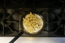 Cavatappi pasta added to sauce and tossed until evenly coated. Step eight in the Cavatappi Carbonara recipe shared by the chefs at Leunig's Bistro as one of their local Vermont recipes made with Monument fresh local heavy cream.