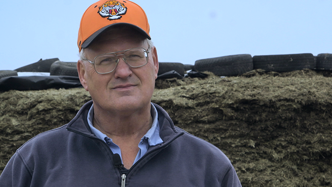 Pete James a man in his fifties with glasses and a hat smiles into camera, one of the team at Monument Farms Vermont Dairy Distributor